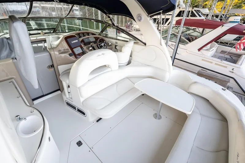 Slide: The Image of 2004 Sea Ray 380 Sundancer yacht interior with white seating and helm station. - 23