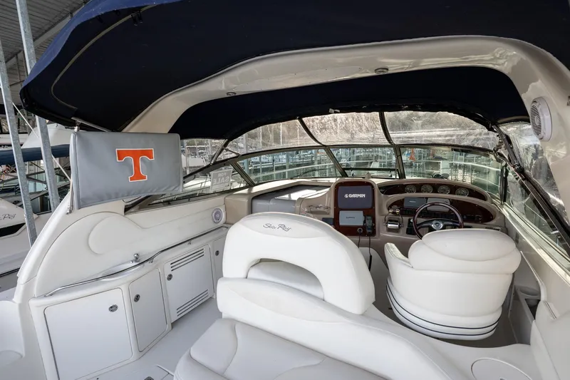 Slide: The Image of 2004 Sea Ray 380 Sundancer cockpit with Garmin navigation, white seating, and canopy. - 24