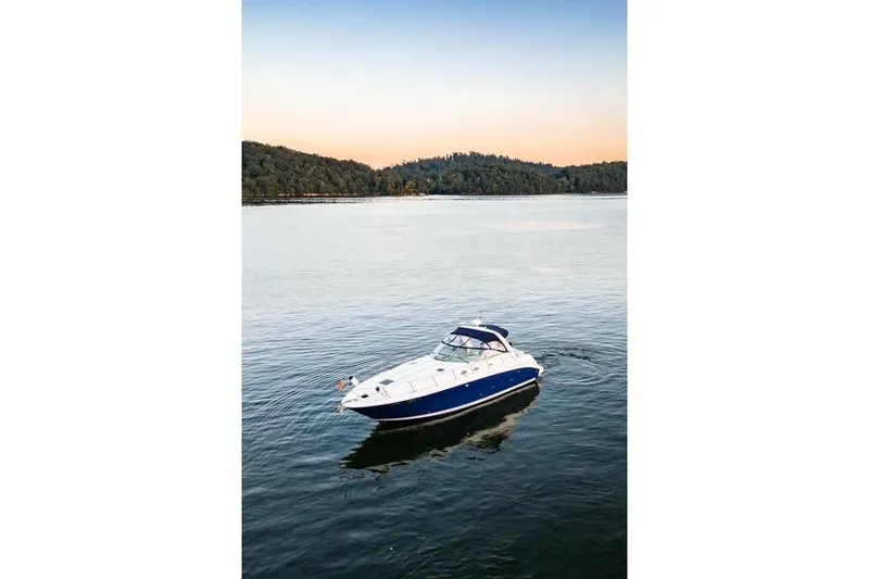 Slide: The Image of 2004 Sea Ray 380 Sundancer yacht on calm water at sunset. - 30