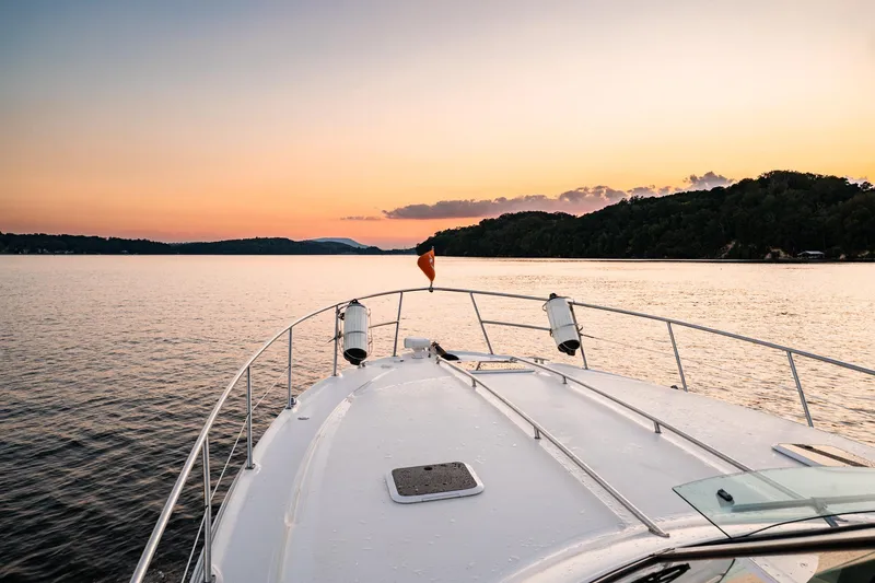 Slide: The Image of 2004 Sea Ray 380 Sundancer yacht cruising at sunset on a serene lake. - 6