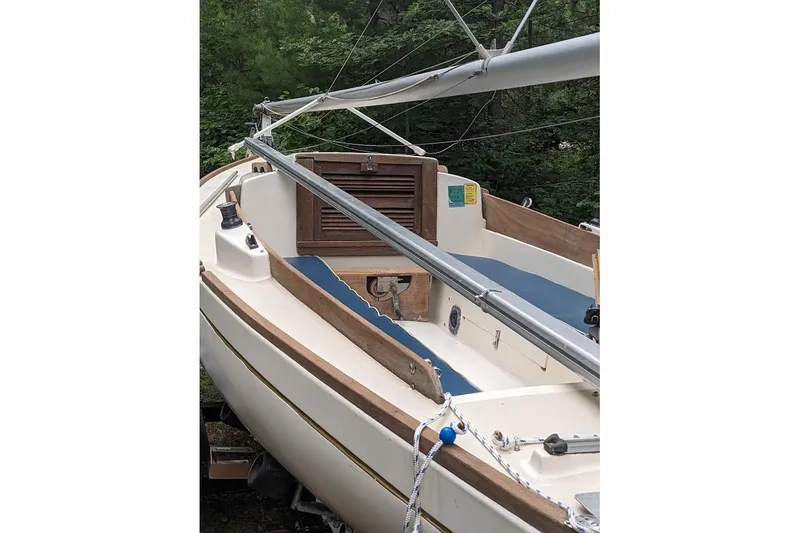 Slide: The Image of 1981 McVay Bluenose sailboat with wooden accents and blue interior, docked outdoors. - 11