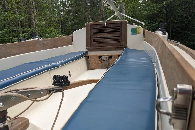 Slide: The Image of 1981 McVay Bluenose sailboat interior with blue cushions and wooden accents. - 8