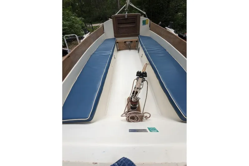 Slide: The Image of 1981 McVay Bluenose sailboat interior with blue cushioned seating and wooden accents. - 9