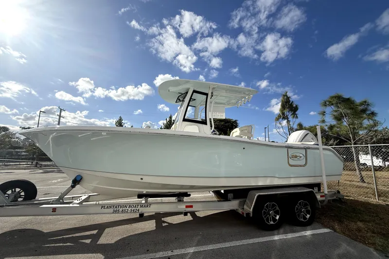 The Image of 2025 Sea Hunt Ultra 255 SE boat on trailer under clear blue sky. - 0