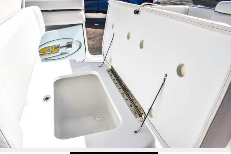 Slide: The Image of 2025 Sea Hunt Ultra 255 SE boat storage compartment with open lid, showcasing interior space. - 18