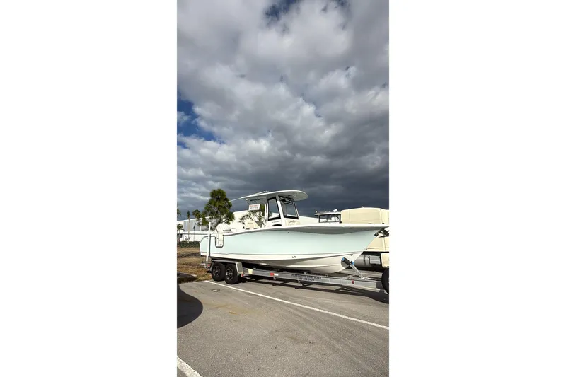 Slide: The Image of 2025 Sea Hunt Ultra 255 SE boat on trailer under cloudy sky. - 19