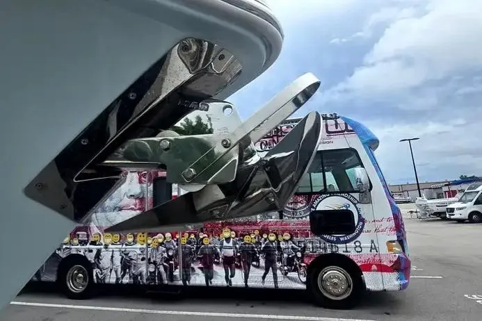 Slide: The Image of 2025 Sea Hunt Ultra 255 SE boat on trailer under clear blue sky. - 5