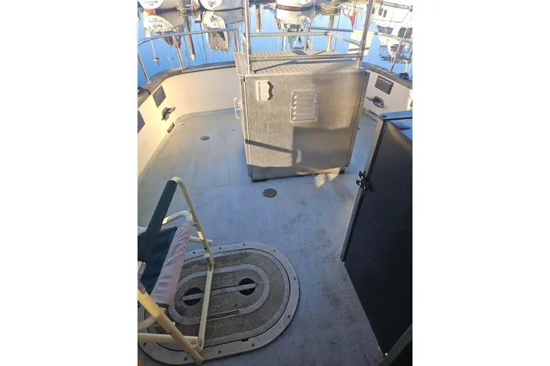 Slide: The Image of 1981 Nordic Tug Cricket boat deck with chairs and open cabin door. - 14