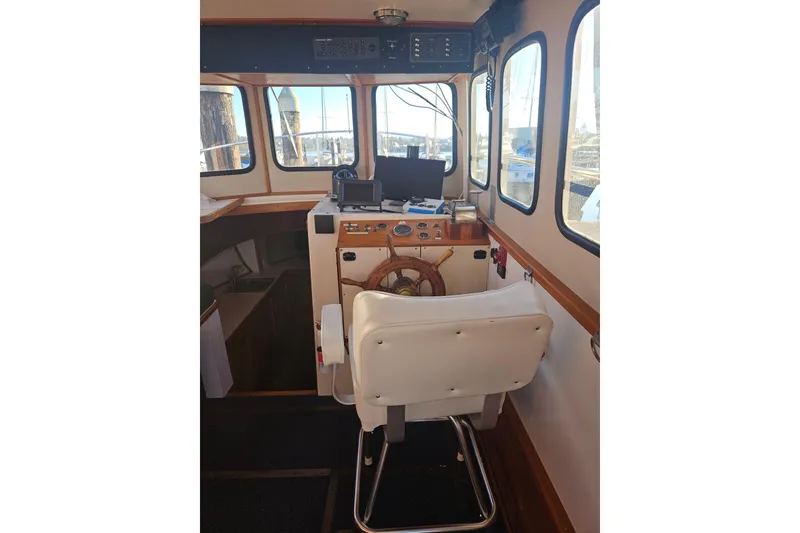 Slide: The Image of 1981 Nordic Tug Cricket boat deck with chairs, fridge, and marina view. - 15