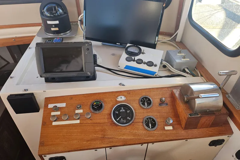 Slide: The Image of Interior of 1981 Nordic Tug Cricket boat, featuring helm and navigation equipment. - 17