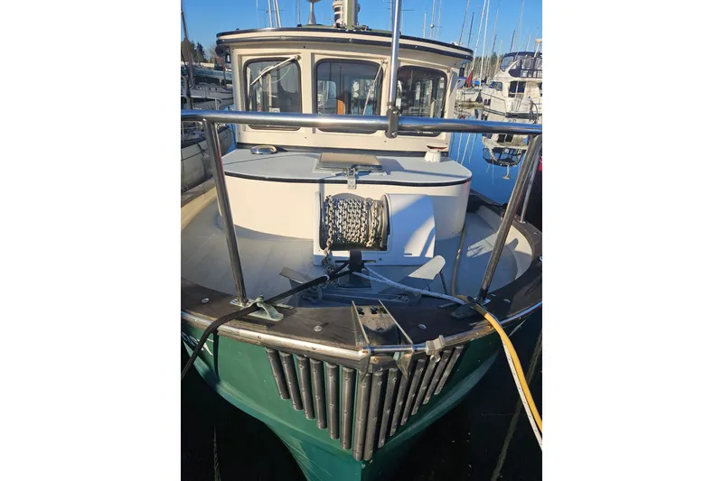 Slide: The Image of 1981 Nordic Tug Cricket boat, "AlliGator III," docked in a marina with clear skies. - 2