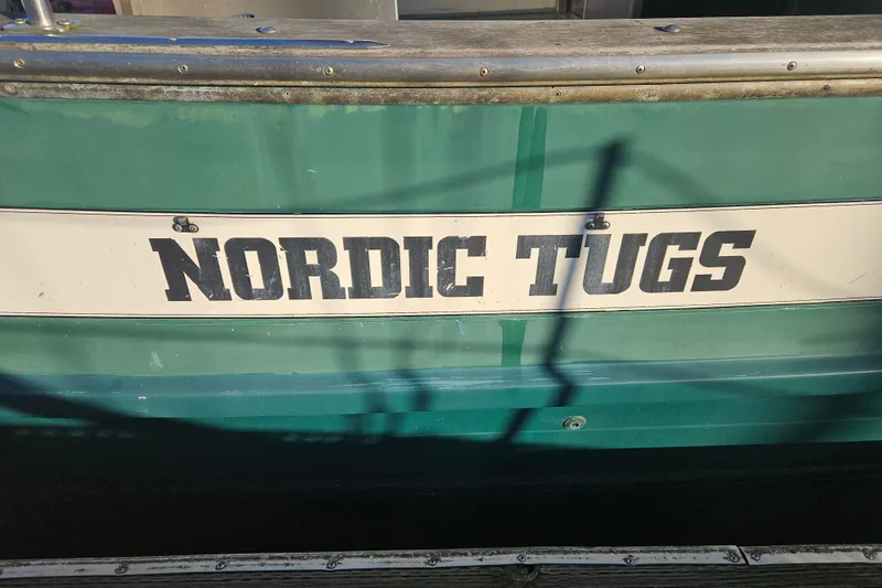 Slide: The Image of 1981 Nordic Tug Cricket "Alligator III" docked at marina, surrounded by sailboats. - 3