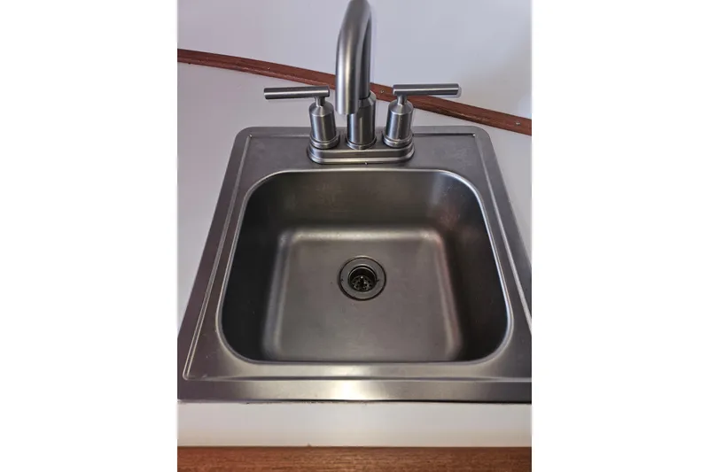 Slide: The Image of Interior cabin of 1981 Nordic Tug Cricket with green bedding and wooden accents. - 36