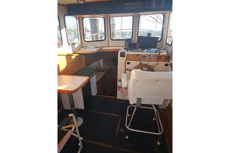 Slide: The Image of 1981 Nordic Tug Cricket boat deck with chair and storage compartments. - 16