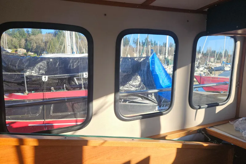 Slide: The Image of 1981 Nordic Tug Cricket in marina, surrounded by sailboats under clear blue sky. - 22