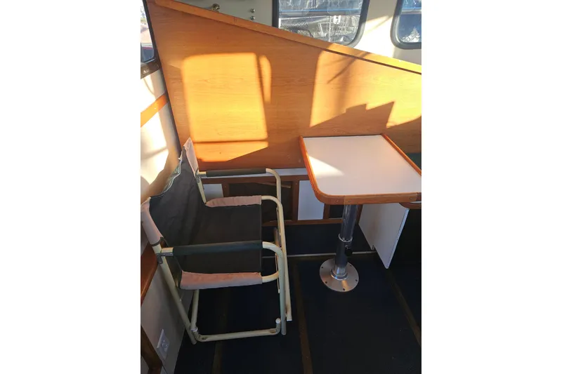 Slide: The Image of Interior view of 1981 Nordic Tug Cricket, showcasing cabin and marina through window. - 27