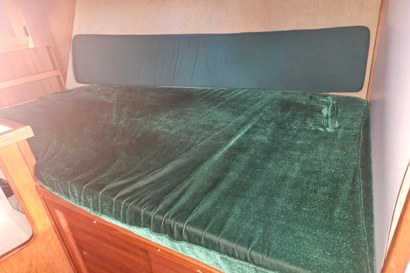 Slide: The Image of 1981 Nordic Tug Cricket interior with wood cabinetry, sink, and green cushioned seating. - 33