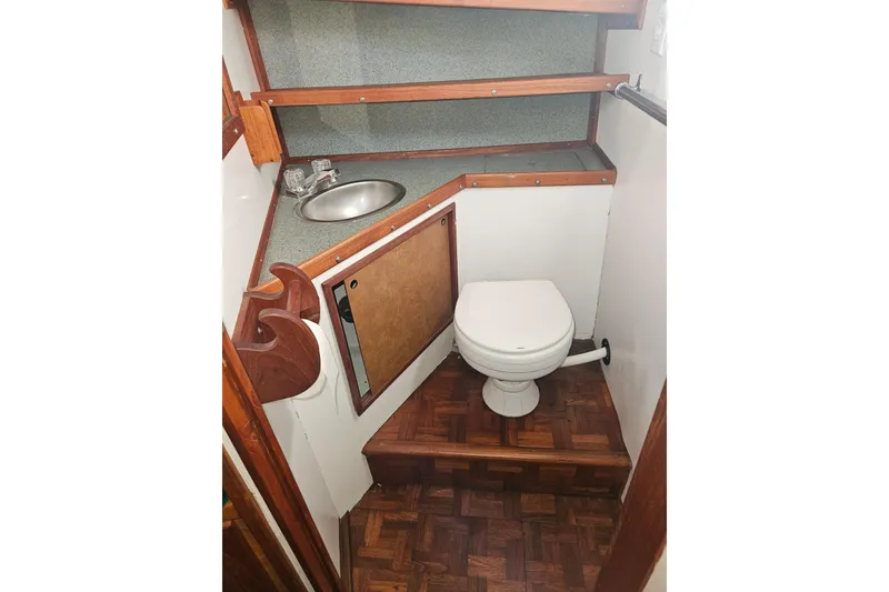 Slide: The Image of 1981 Nordic Tug Cricket interior with wood cabinetry, sink, and green cushioned bed. - 34