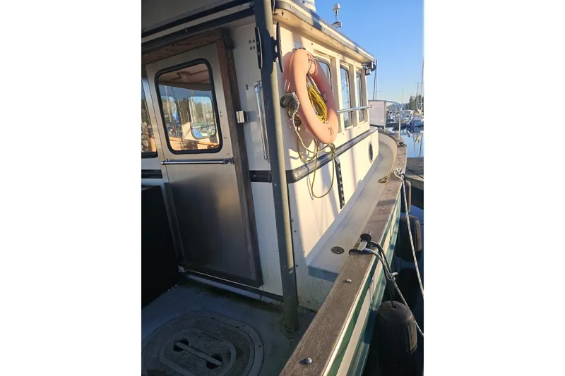 Slide: The Image of 1981 Nordic Tug Cricket boat with "Nordic Tugs" logo on green hull. - 5