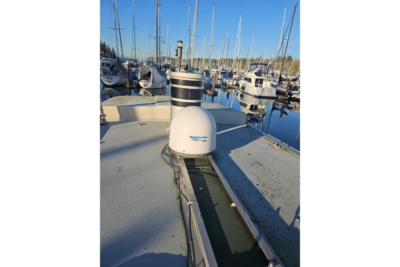 Slide: The Image of 1981 Nordic Tug Cricket boat docked in a marina with clear blue skies. - 66