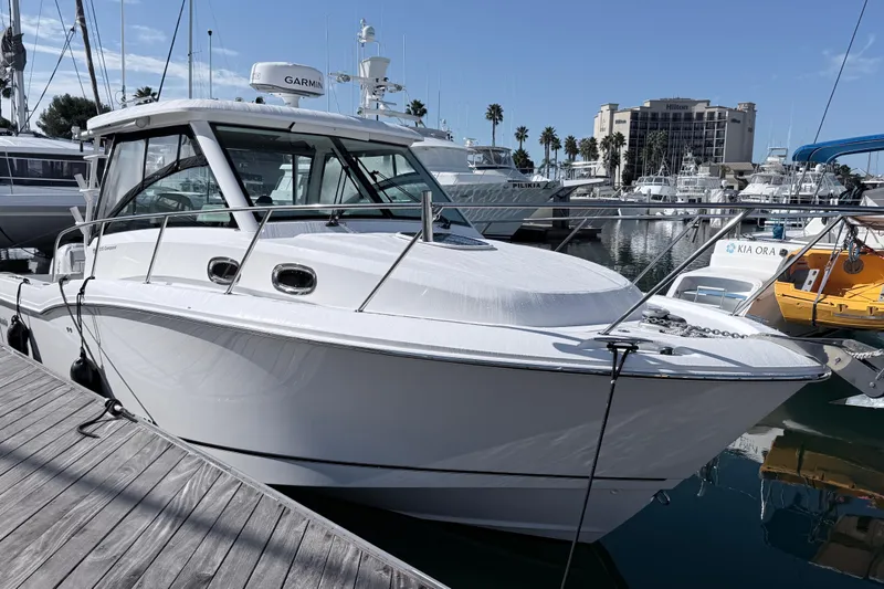 Slide: The Image of 2018 Boston Whaler 315 Conquest docked at marina, clear sky background. - 33