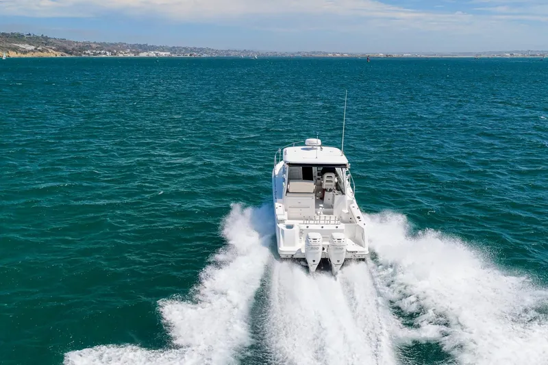 Slide: The Image of 2018 Boston Whaler 315 Conquest cruising on open water, creating a wake behind. - 44