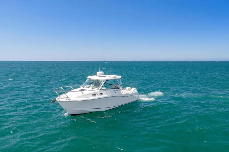 Slide: The Image of 2018 Boston Whaler 315 Conquest cruising on open ocean under clear blue sky. - 78