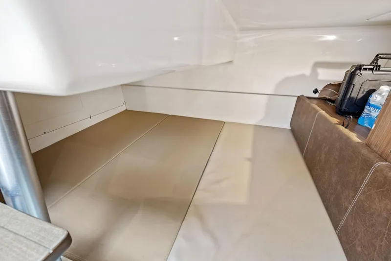 Slide: The Image of Interior cabin of 2018 Boston Whaler 315 Conquest, featuring cushioned seating and storage space. - 40
