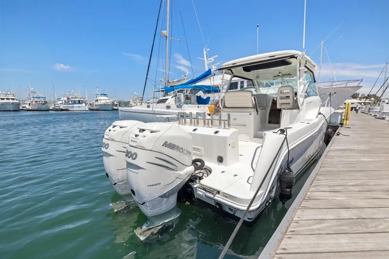 Slide: The Image of 2018 Boston Whaler 315 Conquest docked, featuring dual Mercury outboard engines. - 9