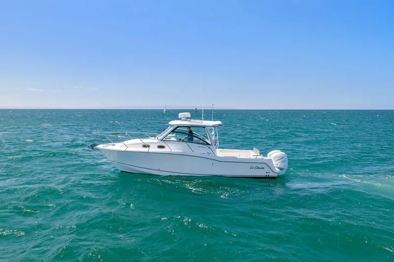 Slide: The Image of 2018 Boston Whaler 315 Conquest cruising on open sea under clear blue sky. - 77