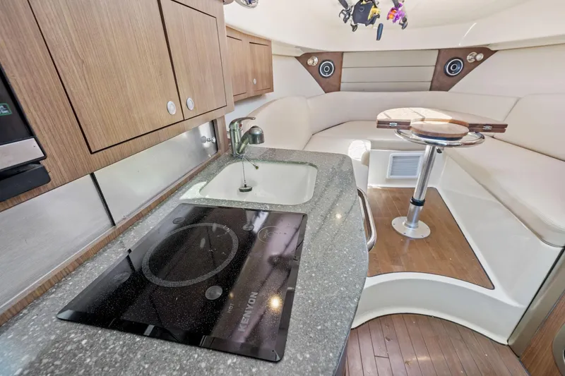 Slide: The Image of Interior of 2018 Boston Whaler 315 Conquest, featuring kitchenette and seating area. - 38