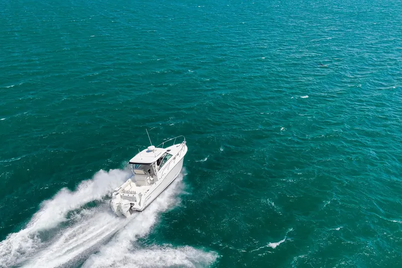 Slide: The Image of 2018 Boston Whaler 315 Conquest cruising on open turquoise waters. - 71