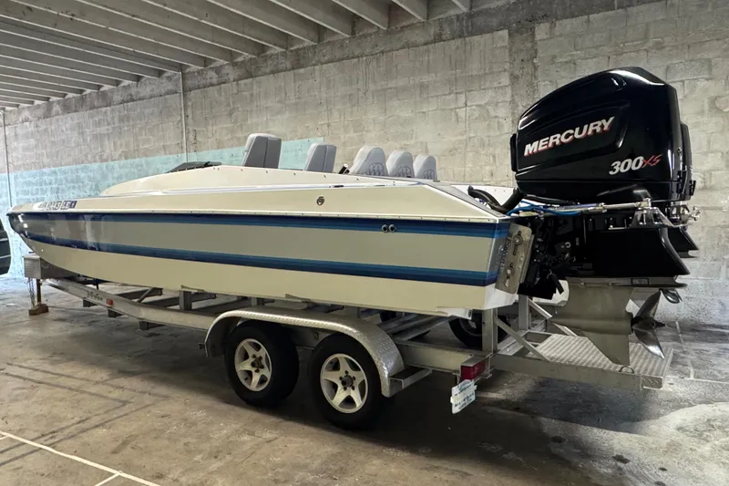 Slide: The Image of 1990 Skater 24 boat with Mercury 300XS engine on trailer in garage. - 10