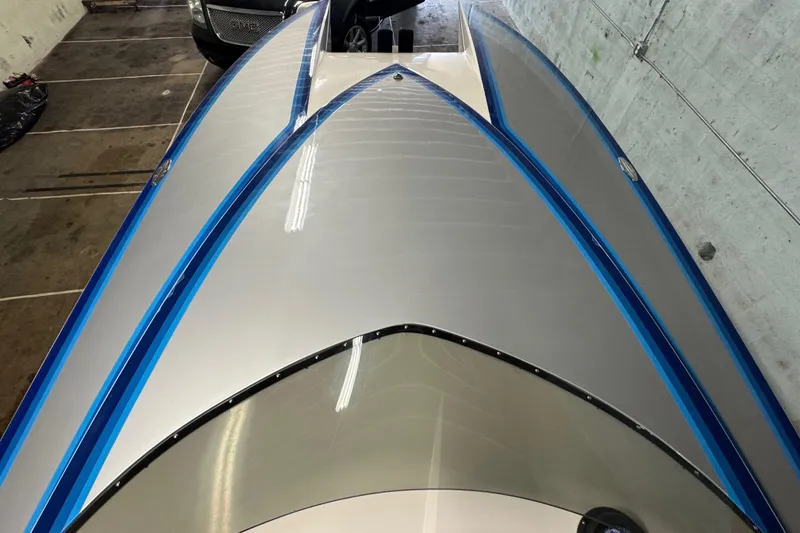 Slide: The Image of 1990 Skater 24 boat with sleek blue and white design in a garage setting. - 25