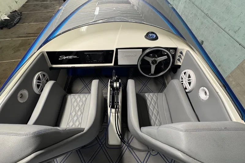 Slide: The Image of Interior of a 1990 Skater 24 boat with gray seats and steering wheel. - 27