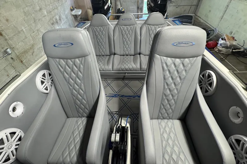 Slide: The Image of Interior of a 1990 Skater 24 boat with gray diamond-stitched seats and speakers. - 33