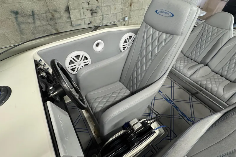 Slide: The Image of Interior of a 1990 Skater 24 boat with gray quilted seats and steering wheel. - 34