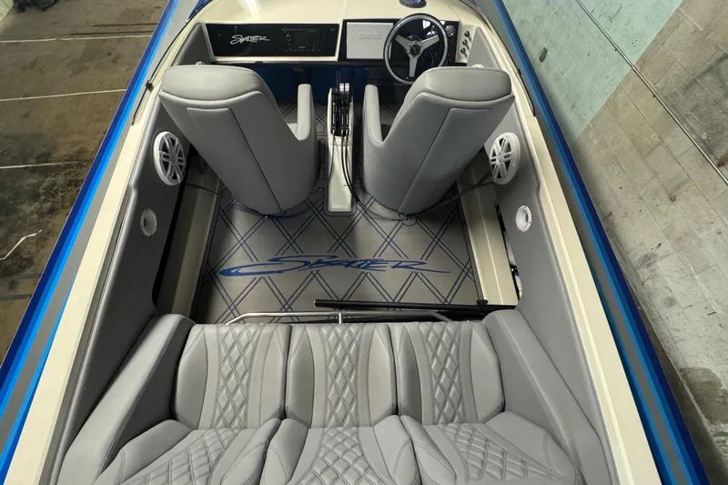 Slide: The Image of Interior of a 1990 Skater 24 boat with gray seating and blue accents. - 36