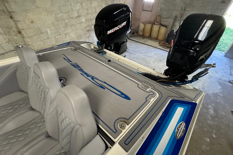 Slide: The Image of 1990 Skater 24 boat with dual Mercury engines in a garage setting. - 39