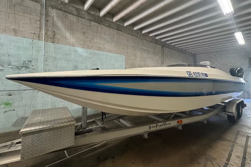 Slide: The Image of 1990 Skater 24 boat on trailer in a concrete garage. - 6