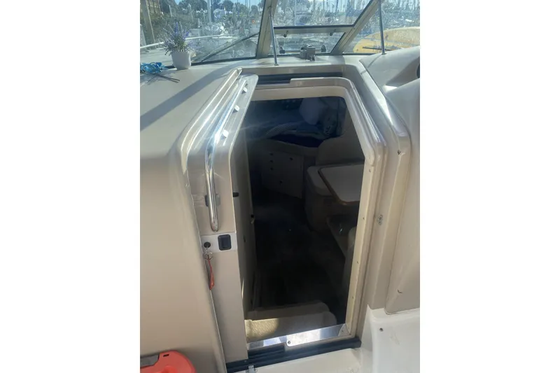 Slide: The Image of 1998 Searay Sundancer cabin entrance with open door, showcasing interior seating area. - 10
