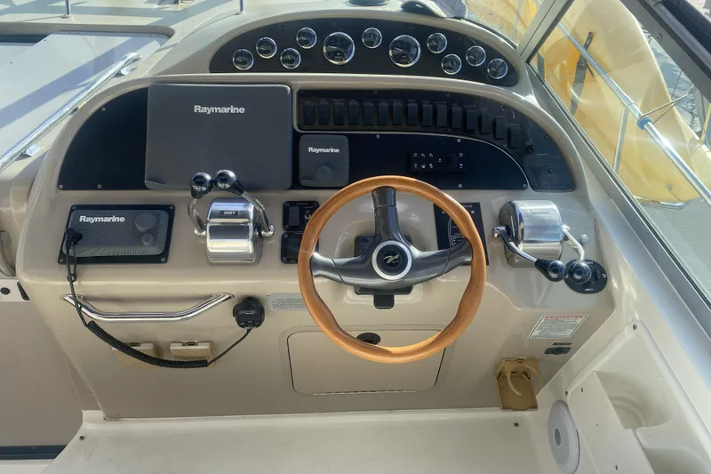 Slide: The Image of 1998 Searay Sundancer helm with Raymarine electronics and wooden steering wheel. - 11