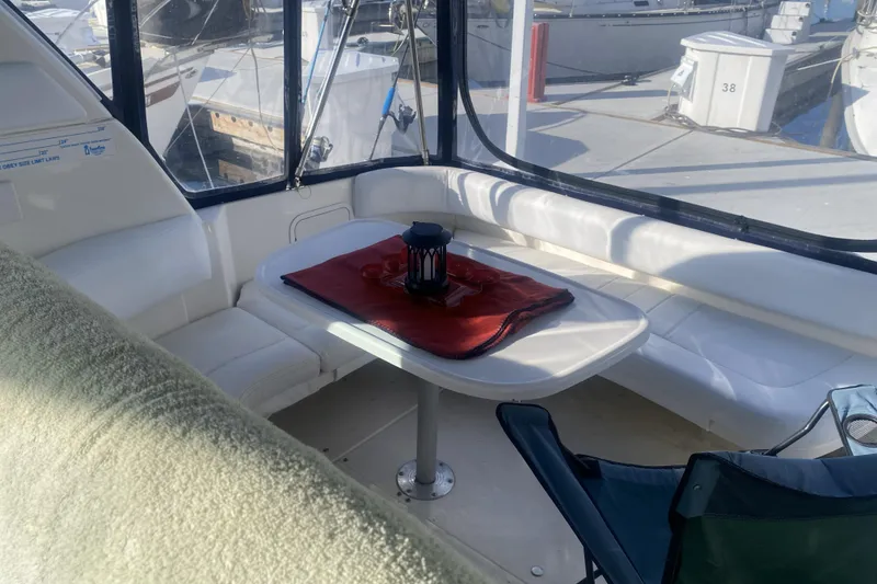 Slide: The Image of 1998 Searay Sundancer boat interior with seating, table, and marina view. - 2