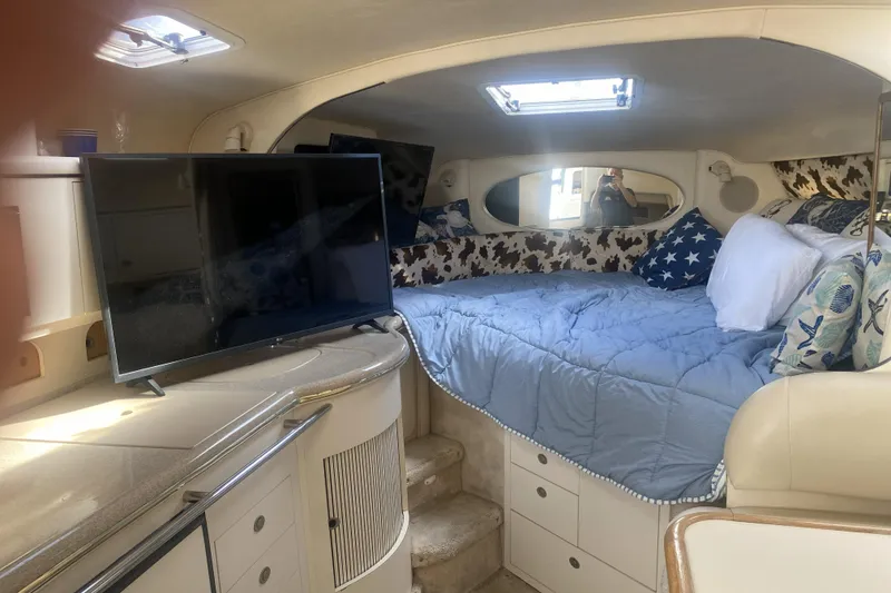 Slide: The Image of Interior of 1998 Searay Sundancer yacht with cozy bed and TV setup. - 7