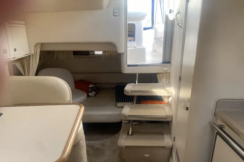 Slide: The Image of 1998 Searay Sundancer cabin interior with seating, stairs, and kitchenette area. - 8