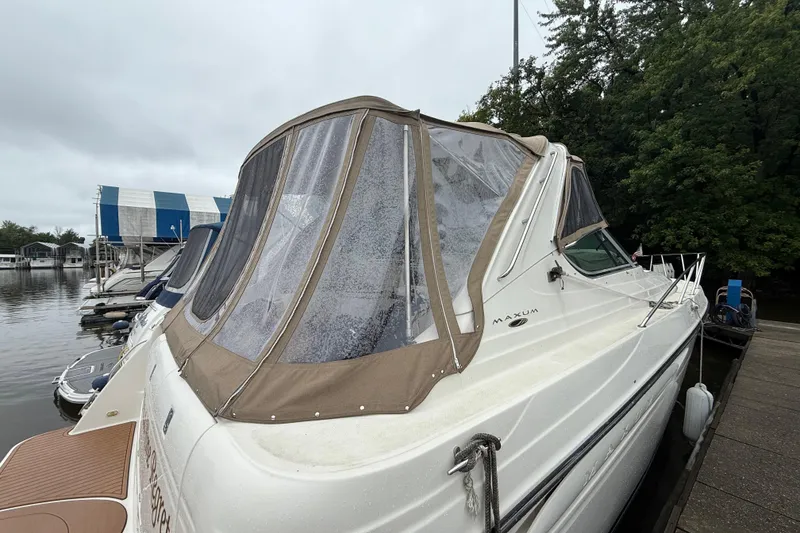 Slide: The Image of 2000 Maxum 3700 SCR boat docked, featuring a beige canopy and sleek design. - 2