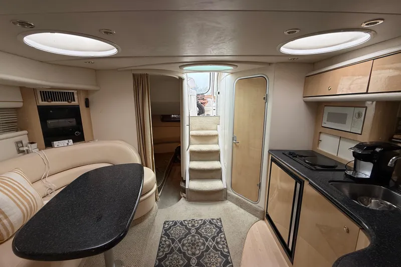 Slide: The Image of Interior of 2000 Maxum 3700 SCR yacht with modern kitchen and cozy seating area. - 4