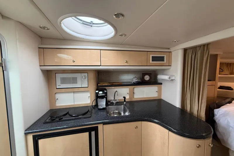 Slide: The Image of 2000 Maxum 3700 SCR yacht interior kitchen with microwave, sink, and stove. - 7