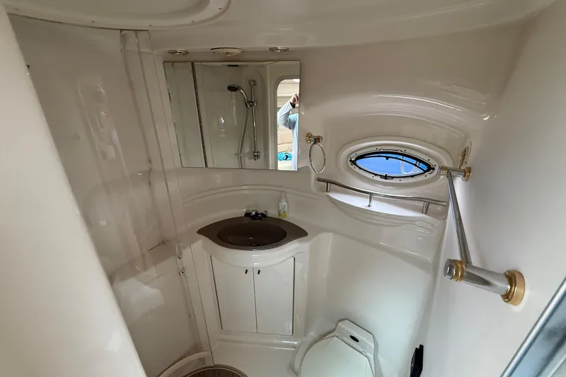 Slide: The Image of 2000 Maxum 3700 SCR yacht bathroom with sink, mirror, and porthole window. - 8