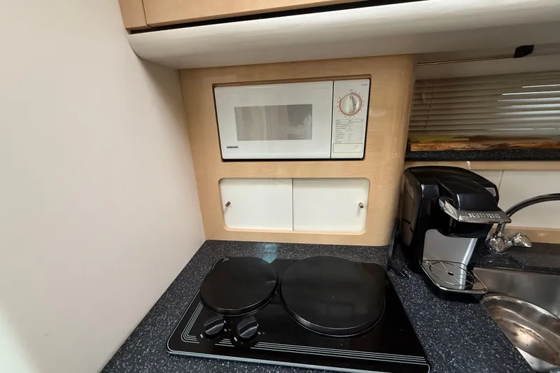 Slide: The Image of Compact kitchen in 2000 Maxum 3700 SCR yacht with microwave, stove, and coffee maker. - 9
